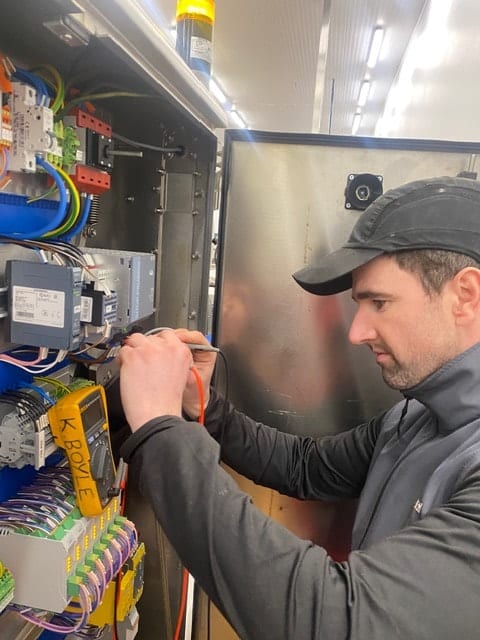 Maintenance engineer inspecting electrical equipment at an industrial site